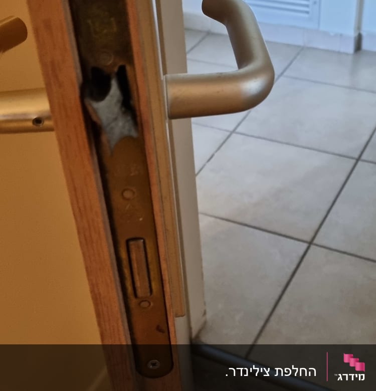 מנעול דלת מתכת עם ידית כסופה על דלת עץ